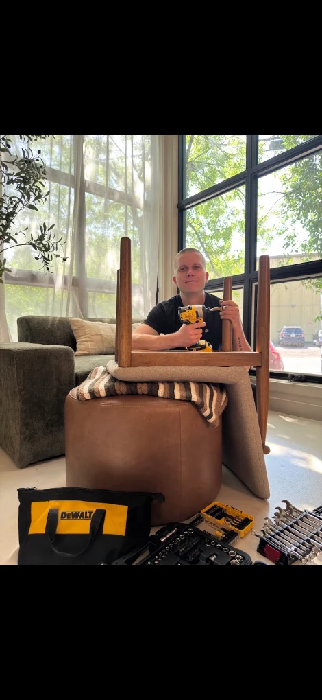 Dmitry of Summit Furniture Assembly with his drill and tool kit, assembling a wooden table in a Calgary home
